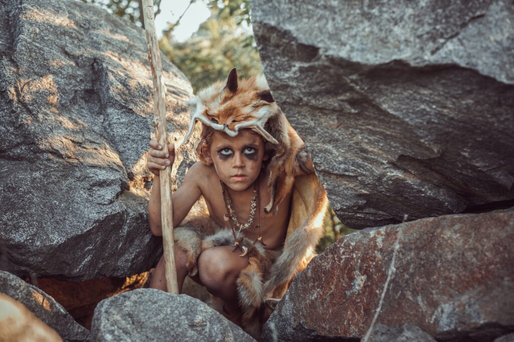 Caveman boy hunting outdoors demonstrating how before there was spoken language there were gestures and grunts which were likely essential for hunting.