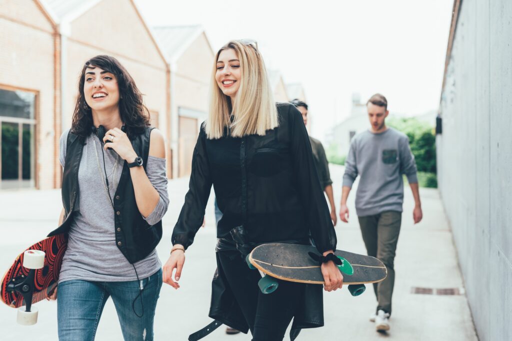 Group of friends skaters walking outdoors having fun chatting is where slang develops throughout the generations.