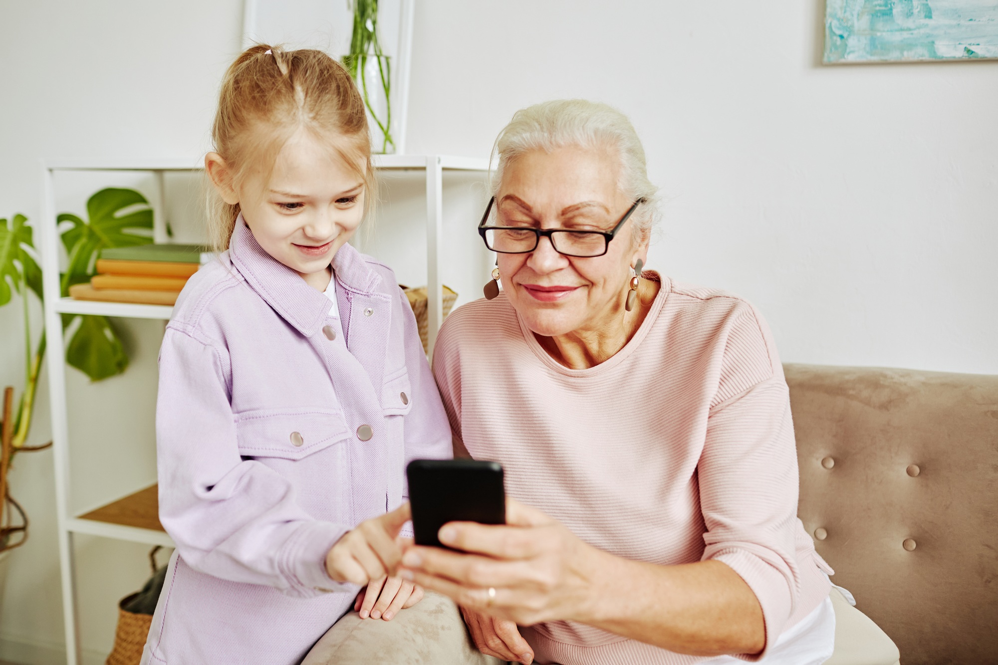 Little Girl with Grandmother at Home sharing different slang usage to help grandma understand her grandchildren