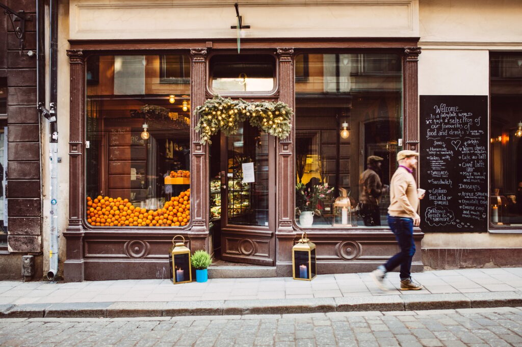 Sweden, Stockholm, Gamla Stan, Man walking by cafe without a store sign.