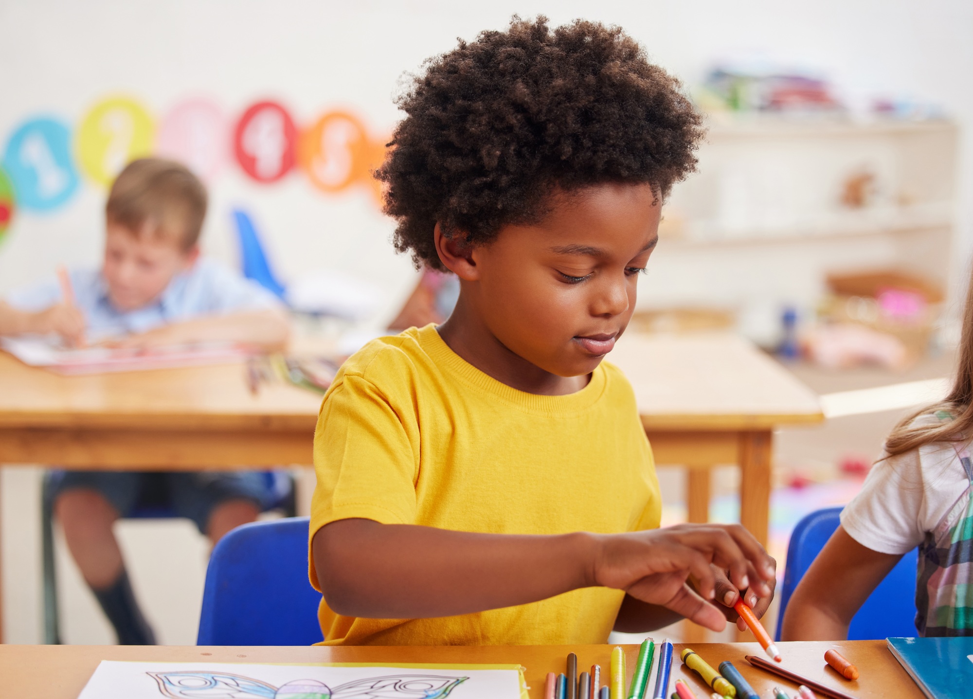 Colouring promotes creativity. Shot of a preschooler colouring in class.