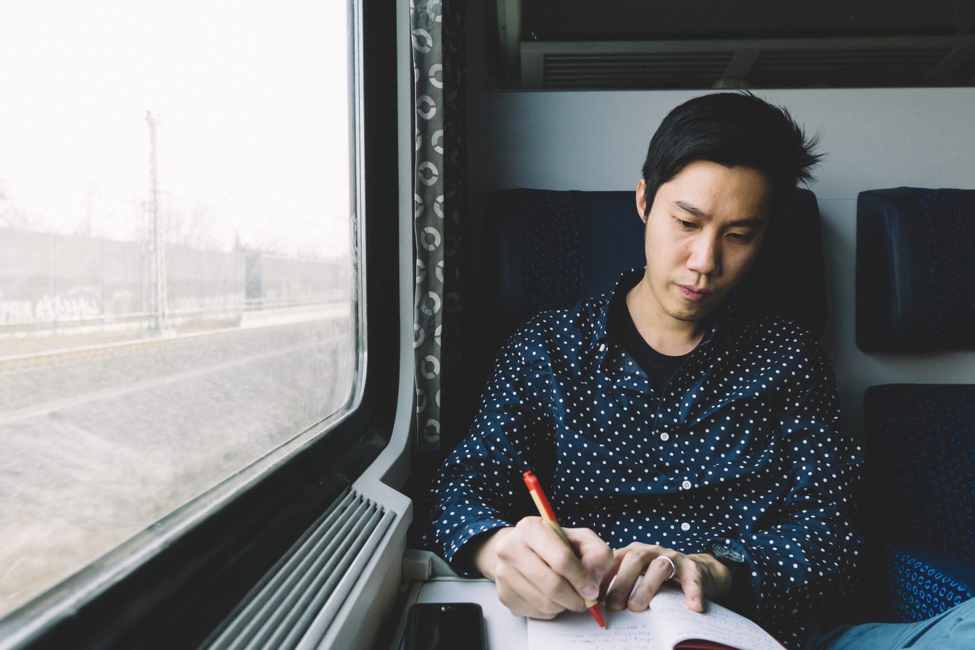 Asian man jotting note on the train